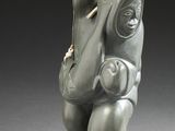 une petite statue représentant un homme avec un sac à dos sur le dos