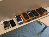several cell phones are lined up on a table in front of a wall