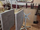 tables and chairs in a restaurant with a clock on the wall