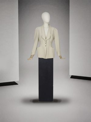 un mannequin vêtu d'une veste blanche et d'une jupe noire