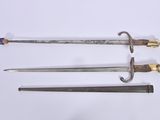 three different types of swords are displayed on a white surface