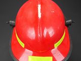 a red fireman ' s hat on a black background