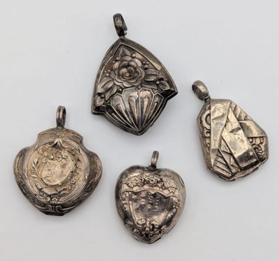 un ensemble de quatre pendentifs en argent de formes et de tailles variées