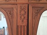 a large wooden armoire with a mirror in it