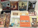 several books on a white table with a lamp on top of it