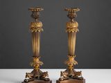 paire de bougeoirs anciens en laiton sur des socles en bois