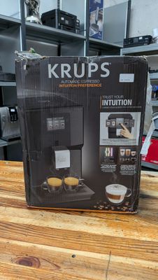 krups coffee machine in the box on a wooden table
