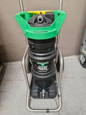 une photo d'un aspirateur vert et noir posé sur un chariot