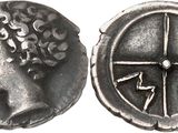 a silver coin with a woman ' s head and a cross on it