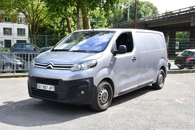 une camionnette argentée garée dans un parking