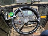 a steering wheel of a military vehicle with a green button