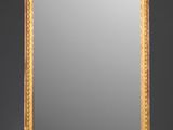 un miroir richement décoré, avec un cadre doré sur fond gris
