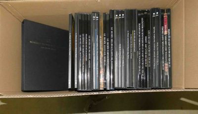une boîte remplie de DVD posée sur une étagère dans une pièce