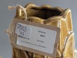 a gold vase with a tag on it sitting on a table