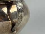 a silver vase that is sitting on a table