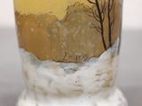 a vase with a painting on it sitting on a table