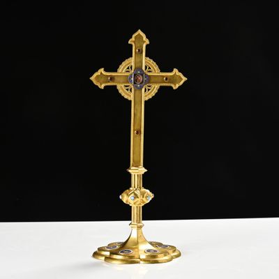 a gold cross on a white table with a black background
