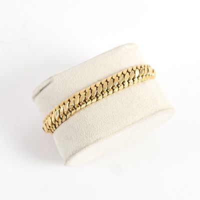 a close up of a gold chain bracelet on a white ring