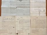 some old papers are sitting on a table with a pen and ink