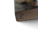 a bronze statue of a dog on a wooden block