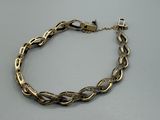 gros plan d'un bracelet en chaîne en or sur une table