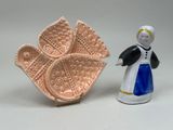une petite figurine représentant une femme et une assiette de nourriture