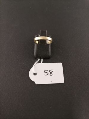 a black and gold ring on a black surface with a price tag