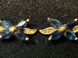 pair of blue and gold flower earrings on a black surface