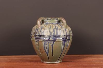 un vase posé sur une table, sur fond marron