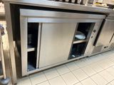 une grande cuisine en inox équipée d'un lave-vaisselle intégré au plan de travail