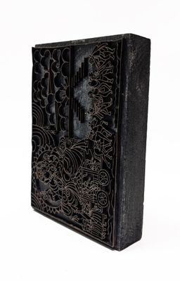 un vieux livre noir orné de motifs complexes sur une couverture blanche