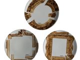 trois assiettes ornées de motifs dorés et blancs sur un fond blanc