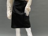a mannequin wearing a white blouse and black skirt