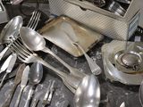 many silverware on a table with a box of silverware in the background