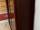 a refrigerator with a wooden door in a room