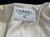Étiquette de la boutique Chanel sur une robe blanche sur fond noir