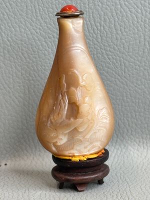 a picture of a small vase on a stand on a white surface