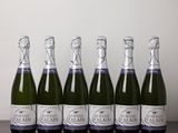 six bottles of sparkling wine lined up on a wooden table