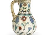 un vase blanc orné de fleurs bleues et rouges