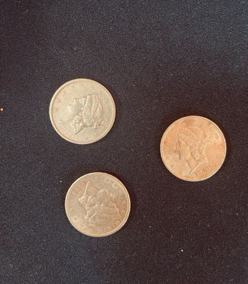 trois types de pièces différents posés sur une surface noire, dont l'une représente une femme et une autre un homme
