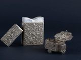 two silver metal objects sitting next to each other on a black surface