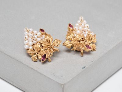 a close up of a pair of gold and pearl earrings