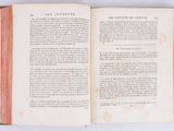 an open book on a white surface with a red border