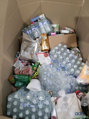une boîte en carton remplie de bouteilles d'eau et d'autres objets