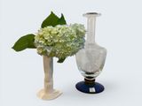 two vases with flowers in them sitting next to each other