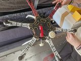 a man sitting on a couch holding a remote control helicopter