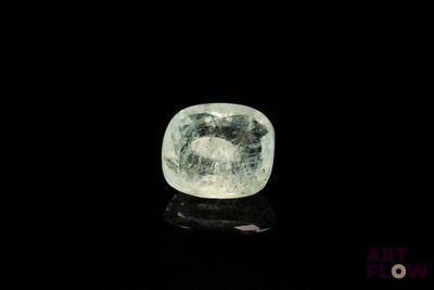 a close up of a green and white diamond on a black surface