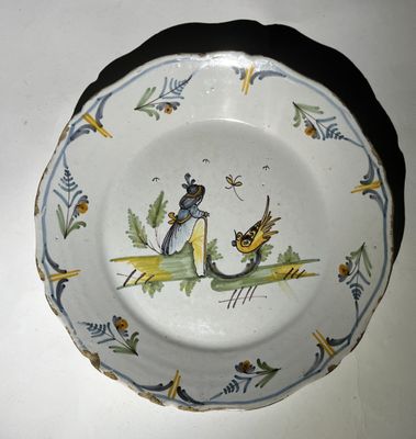 une assiette avec l'image d'une dame et d'un oiseau