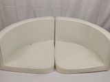 two white chairs sitting next to each other on a white table