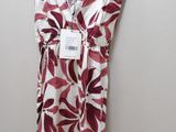 a white and red dress hanging on a hanger on a wall